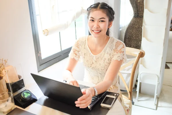 Freelance e business asian women using laptop computer in coffee shop co-networking mange ment concept