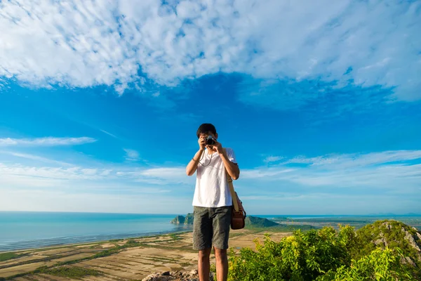 Artista hombres de pie en la cima de acantilado de montaña y disfrutar de tomar p — Foto de Stock