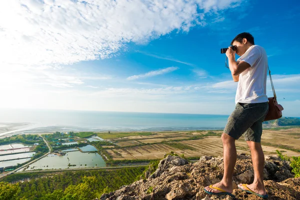 Artista hombres de pie en la cima de acantilado de montaña y disfrutar de tomar p — Foto de Stock