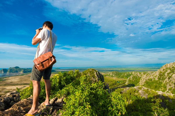 Artista hombres de pie en la cima de acantilado de montaña y disfrutar de tomar p — Foto de Stock