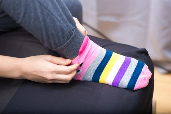 Тонкая нога азиатка в тёплом свитере и шерстяных носках на кровати — стоковое фото