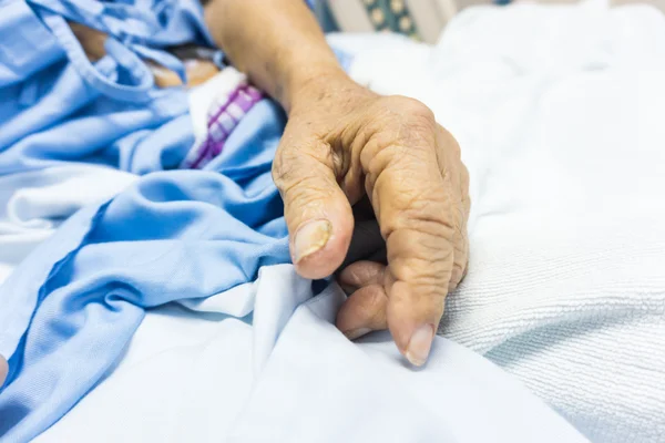 Detailní záběr staré muž ruka leží na nemocniční posteli — Stock fotografie