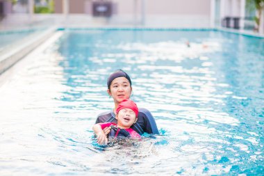 Güzel genç Asyalı kadın ile iki yaşındaki bebeği rahatlatıcı