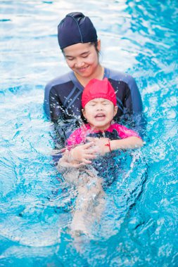 Having oyunculuk ile Asya çocuklar mutlu saat yüzme havuzunda Genç aktif anne