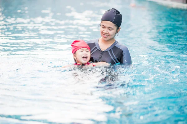 Ung aktiv mamma ha kul i en pool med asiatiska kid — Stockfoto