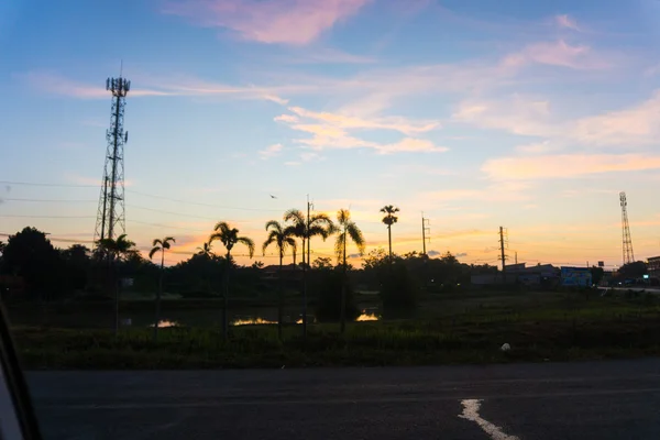 Nubes coloridas y palmeras en el horizonte al amanecer — Foto de Stock