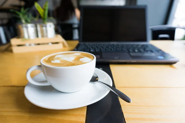 Kubek biały expresso kawa z laptopa w kawiarni — Zdjęcie stockowe