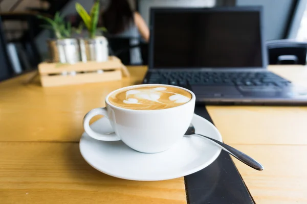 Latte arte xícara de café e laptop para negócios . — Fotografia de Stock
