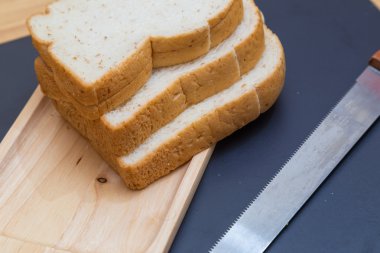 Kepekli ekmek ahşap plaka siyah arka plan üzerine dilimlenmiş 