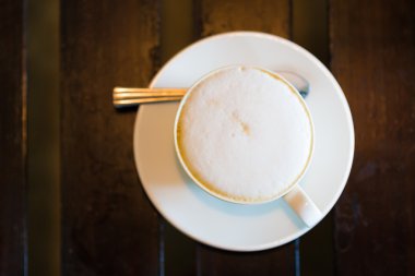 Tahta masada bir fincan sıcak latte sanat kahvesi. 