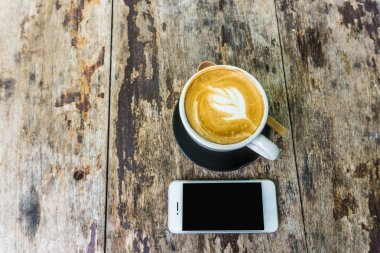 Latte Kahve Kupası ve ahşap masa iş için cep telefonu