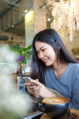 Asyalı kadın café'de sıcak latte kahve içme