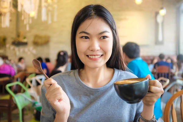 Ασιατικές γυναίκα πίνοντας ζεστό latte καφέ στο καφενείο — Φωτογραφία Αρχείου