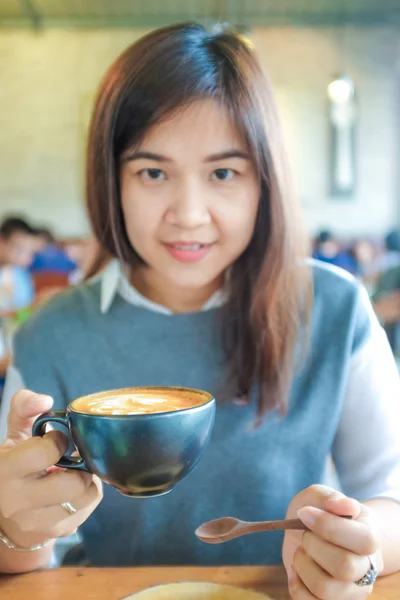 年轻的亚洲女孩在时髦的咖啡馆里喝咖啡 — 图库照片