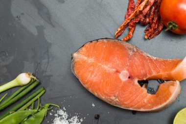 Somon fileto kireç biber domates tuz ile düz siyah kayalar üzerinde bir