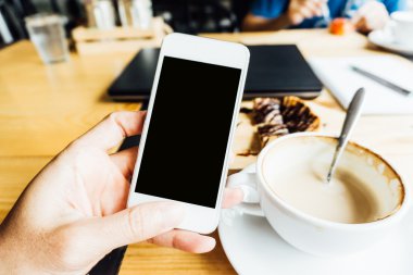 Yemekten sonra kahve ve tatlı ile boş smartphone kullanan adam