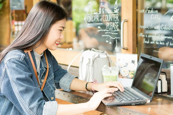 Young asian woman wear jean shirt using laptop computer — Stock Photo, Image