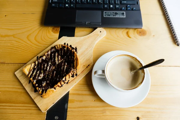 Caffè per laptop e caffellatte su tavolo in legno — Foto Stock