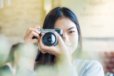 Asian beautuful women use camera totke photo forground blurred clipart