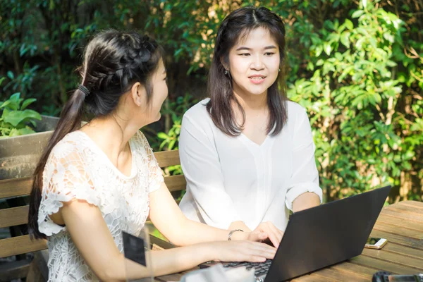 Negócios mulheres asiáticas discutindo plano de negócios no laptop no café — Fotografia de Stock