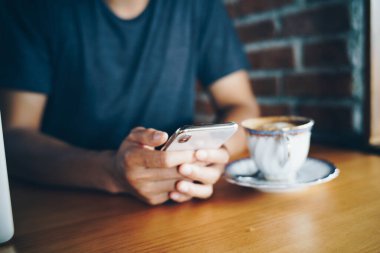 İş adamları kafeteryada otururken akıllı telefon kullanır.