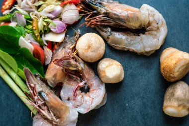 Üst manzara deniz ürünleri Tom yum kung pişirmeye hazır, geleneksel Tayland baharatlı karides ve sebzeli çorba