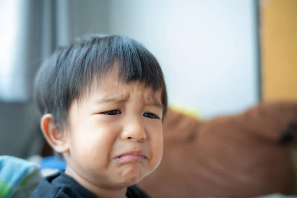 Little asian boy crying bitterly in room of house facial face mood
