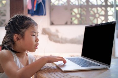 Evde dizüstü bilgisayarda kelime yazan mutlu Asyalı kız.