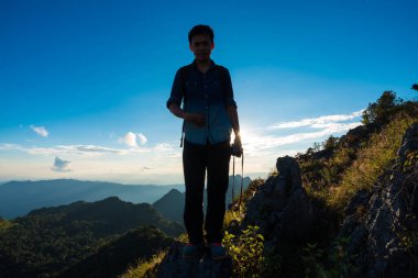 Bir dağın kenarında duran fotoğrafçı güzel günbatımının keyfini çıkarıyor. Mavi gökyüzü bulutu, Doi Chiang Daw, Tayland