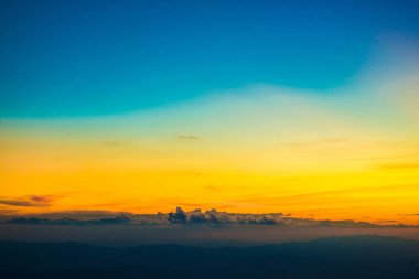 Renkli kümülüs günbatımı bulutları güneş doğayı örtüyor.