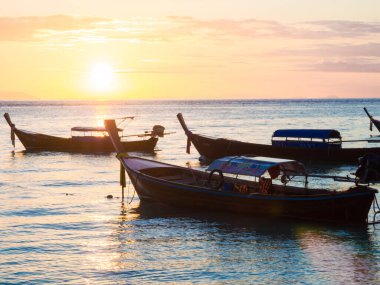 Sahilde gün batımında dramatik gökyüzü, doğayı bulutlandırıyor.
