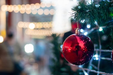 Lüks süs kırmızı top Noel ağacına asılıyor Mutlu Noeller süpermarketinde süsleniyor