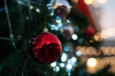 Lüks süs kırmızı top Noel ağacına asılıyor Mutlu Noeller süpermarketinde süsleniyor