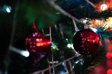 Arka planda Noel ağacı Bokeh çelenklerindeki klasik kırmızı topları kapatın. Yeni yıl konsepti.