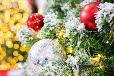 Yılbaşı ağacındaki renkli topları kapatın. Arka planda Bokeh çelenkleri var. Yeni yıl konsepti.