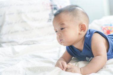 Sevimli 6 aylık erkek bebek beyaz battaniyenin üzerinde yatıyor sağlıklı erkek çocuk konsepti