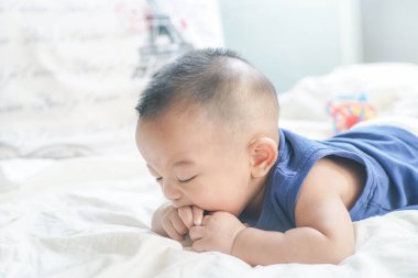 Sevimli 6 aylık erkek bebek beyaz battaniyenin üzerinde yatıyor sağlıklı erkek çocuk konsepti