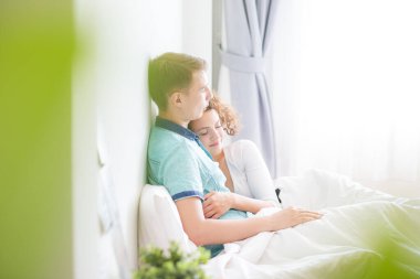 Romantik aşk çifti beyaz yataklı beyaz bir çiftte sevişiyor.