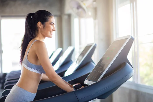 Attractive asian sport women running on treadmil with friend in sport gym healthy women