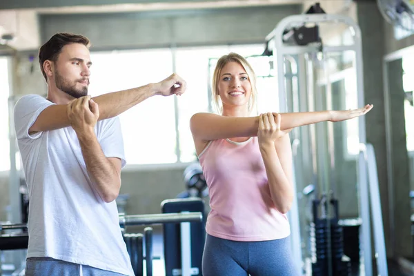 Sport couple stretching muscle before sport activity in fitness gym club happy exercise together