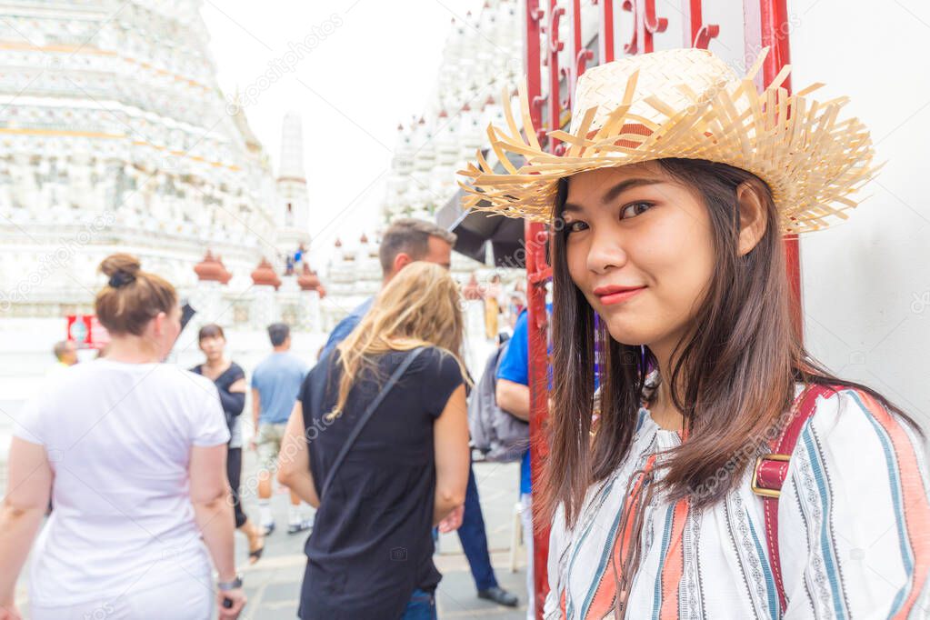 Beautiful tourist asian women travel in Wat arun buddha attractive temple white pagoda sightseeeing in Bangkok Thailand