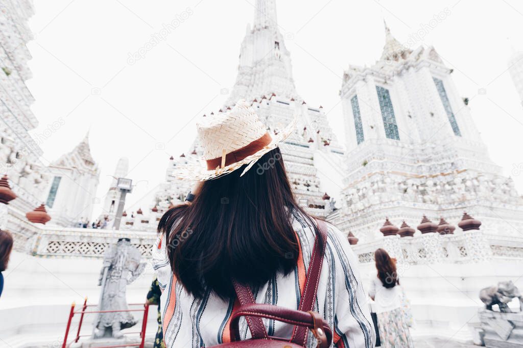 Beautiful tourist asian women travel in Wat arun buddha attractive temple white pagoda sightseeeing in Bangkok Thailand