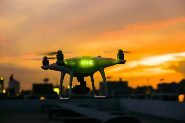 Drone flying over city building against colorful sky sunset landscape