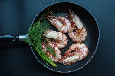 Siyah tabakta kızarmış deniz karidesi.