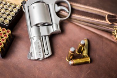 .44 magnum koli tabancası. Deri arka plandaki kişisel silahta kurşun var.