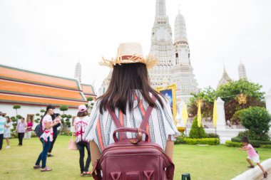 Wat Arun 'u ya da Temple of Dawn' ı ziyaret ederken gülümseyen Asyalı bir turist kız.