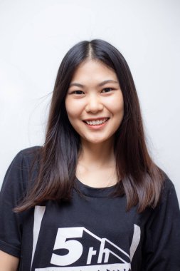 Genç, güzel Asyalı kadın beyaz arka planda siyah tişörtle poz veriyor.