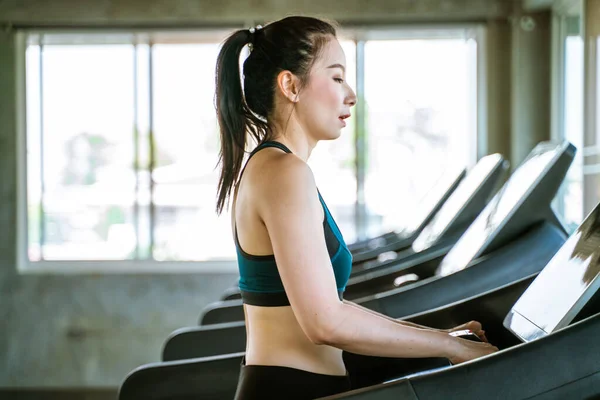 亚洲女子在健身房的跑步机上慢跑 有氧运动 — 图库照片
