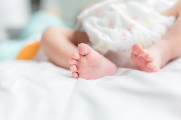 可爱的小宝宝躺在床上 新生的小宝宝脚踏在白毛毯上 — 图库照片