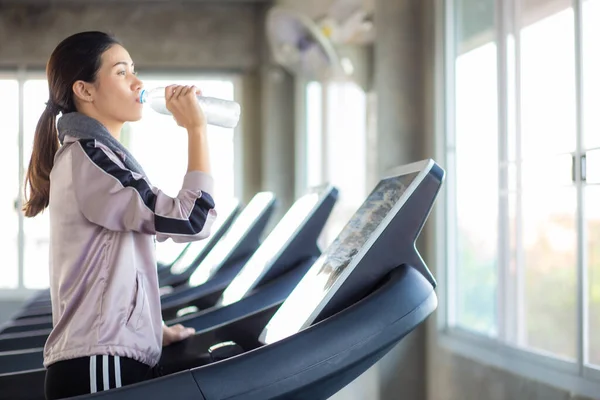 Sport women leisure and drink water after burn running on treadmill Women in gym